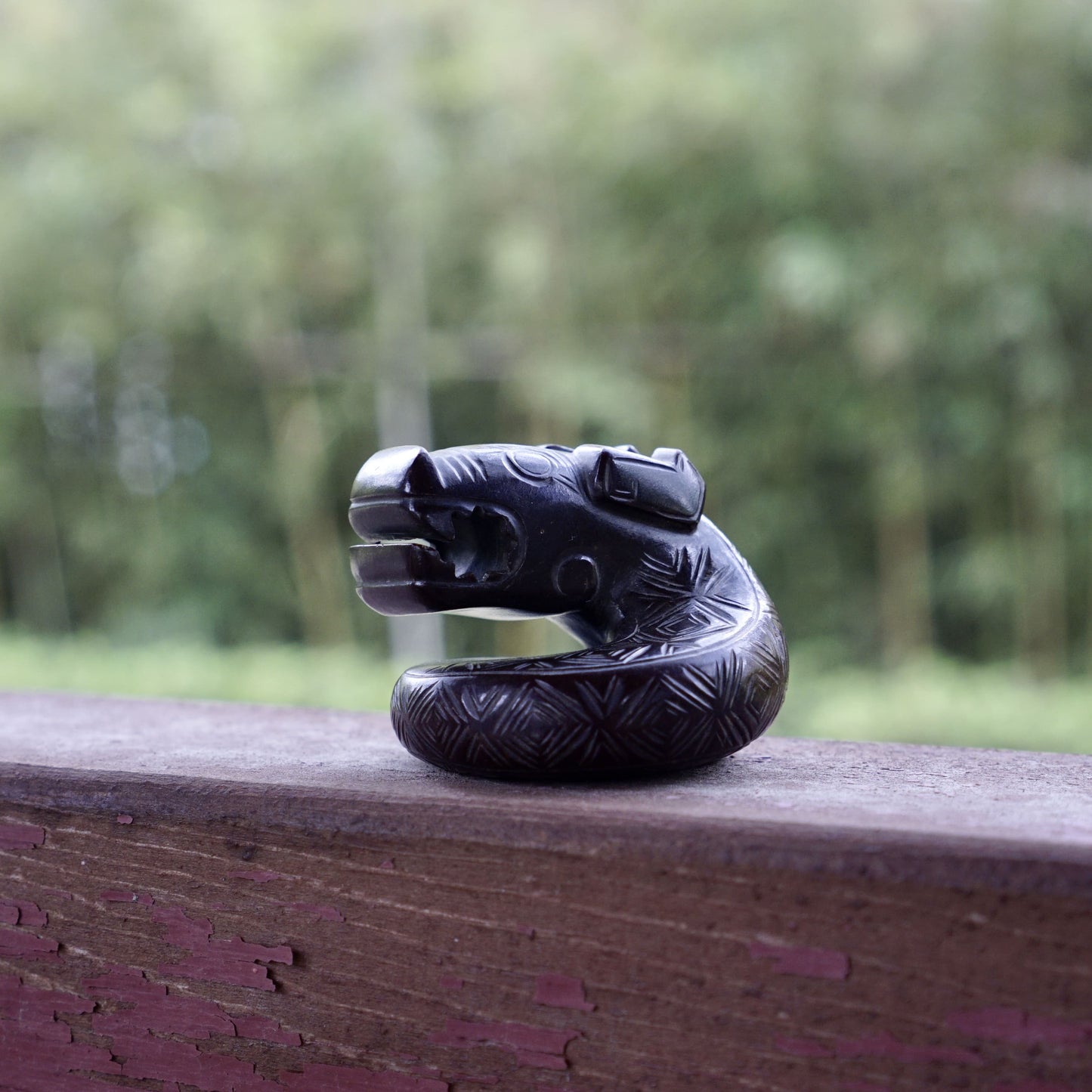 A fine round sculpture of a small dragon with black lacquer