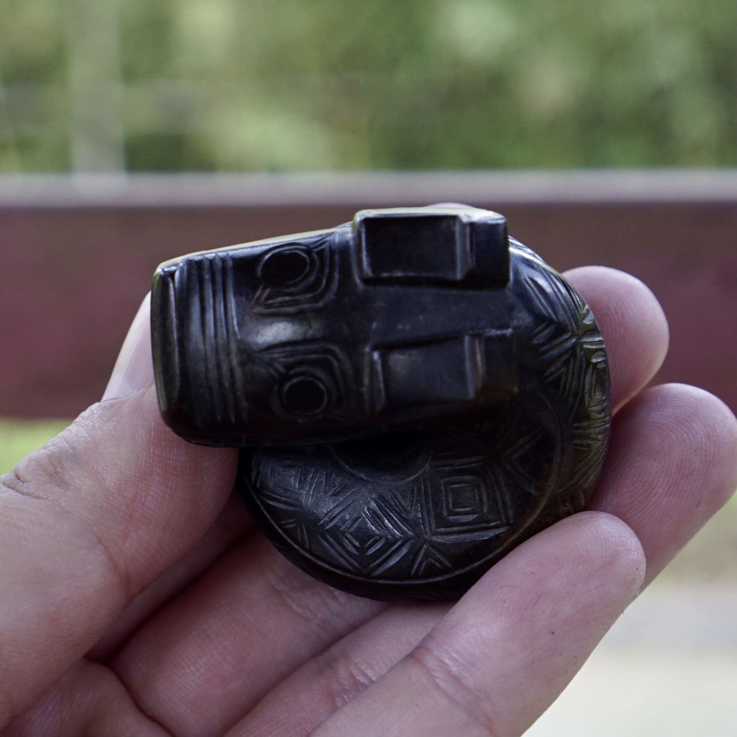 A fine round sculpture of a small dragon with black lacquer