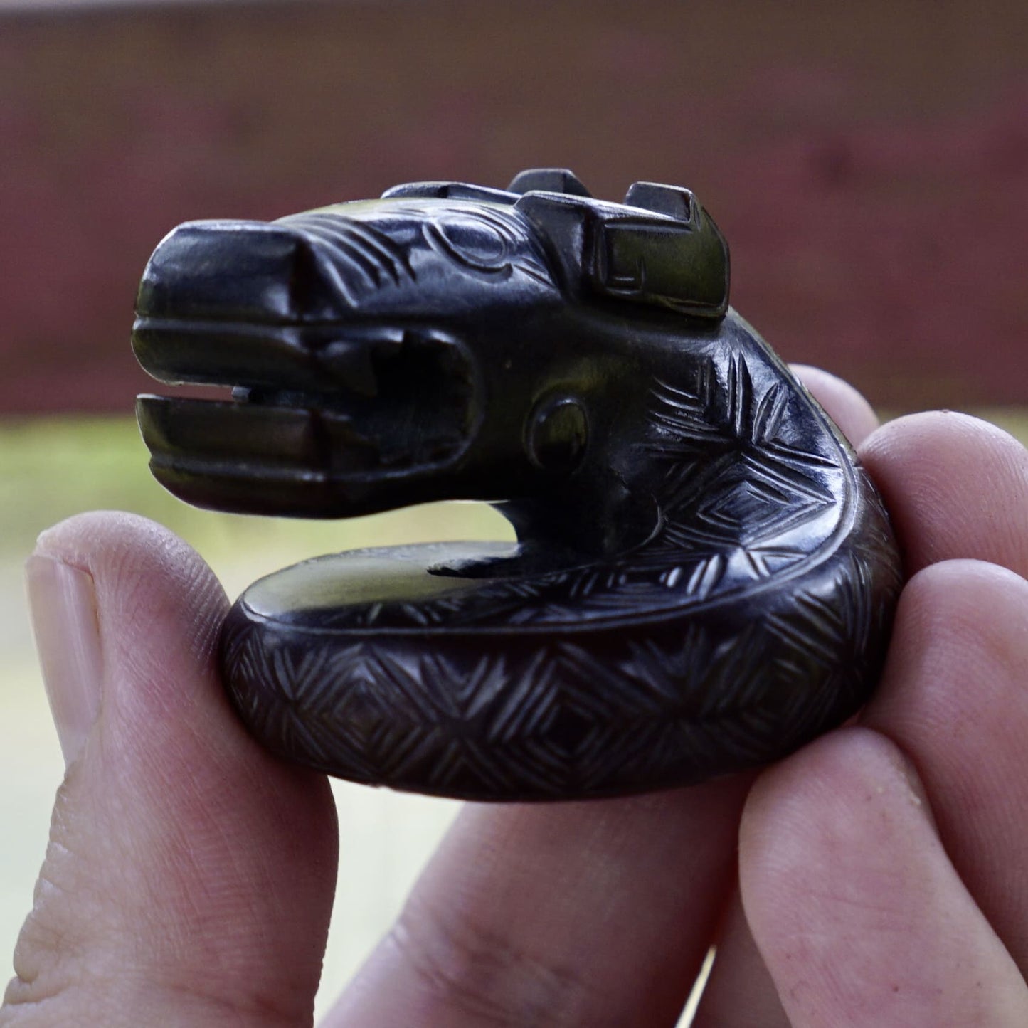 A fine round sculpture of a small dragon with black lacquer