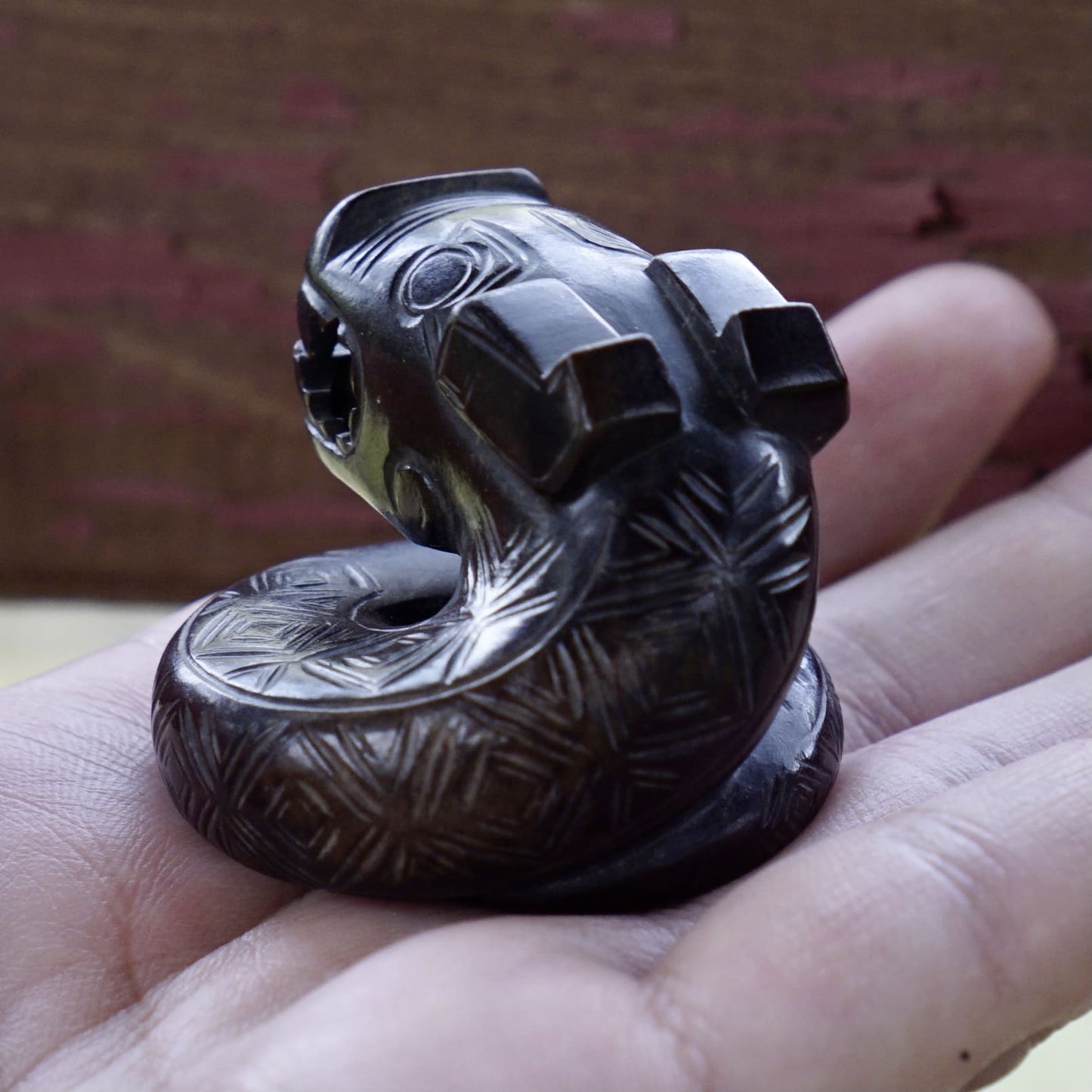 A fine round sculpture of a small dragon with black lacquer