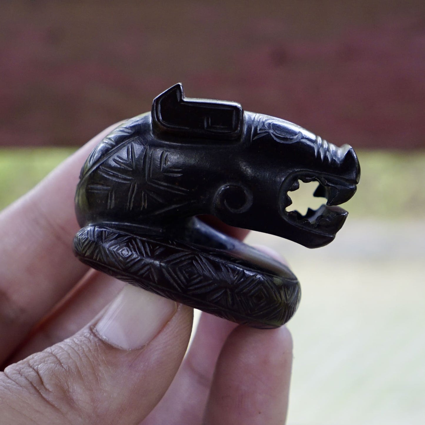 A fine round sculpture of a small dragon with black lacquer