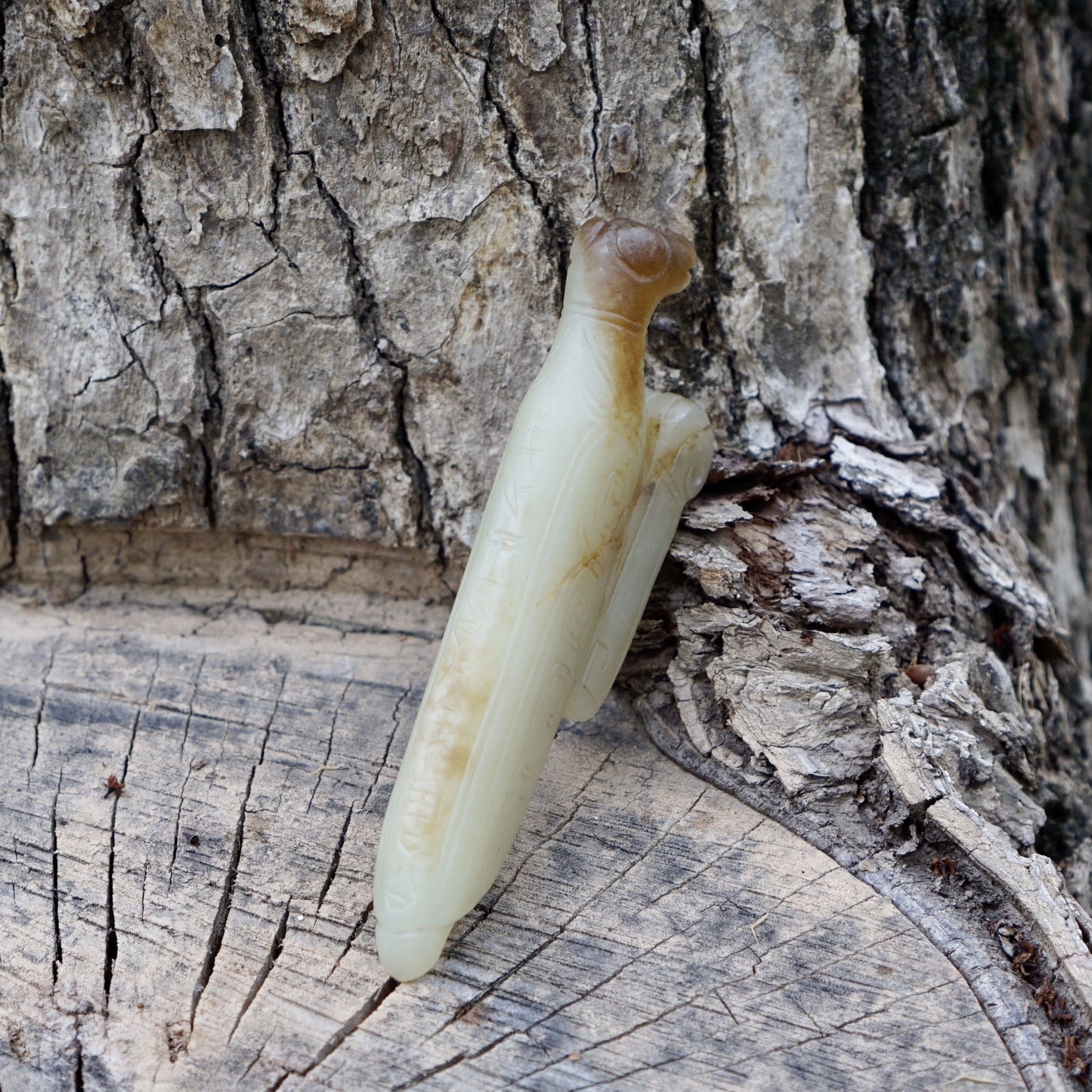 A white jade mantis with an inscription on the back