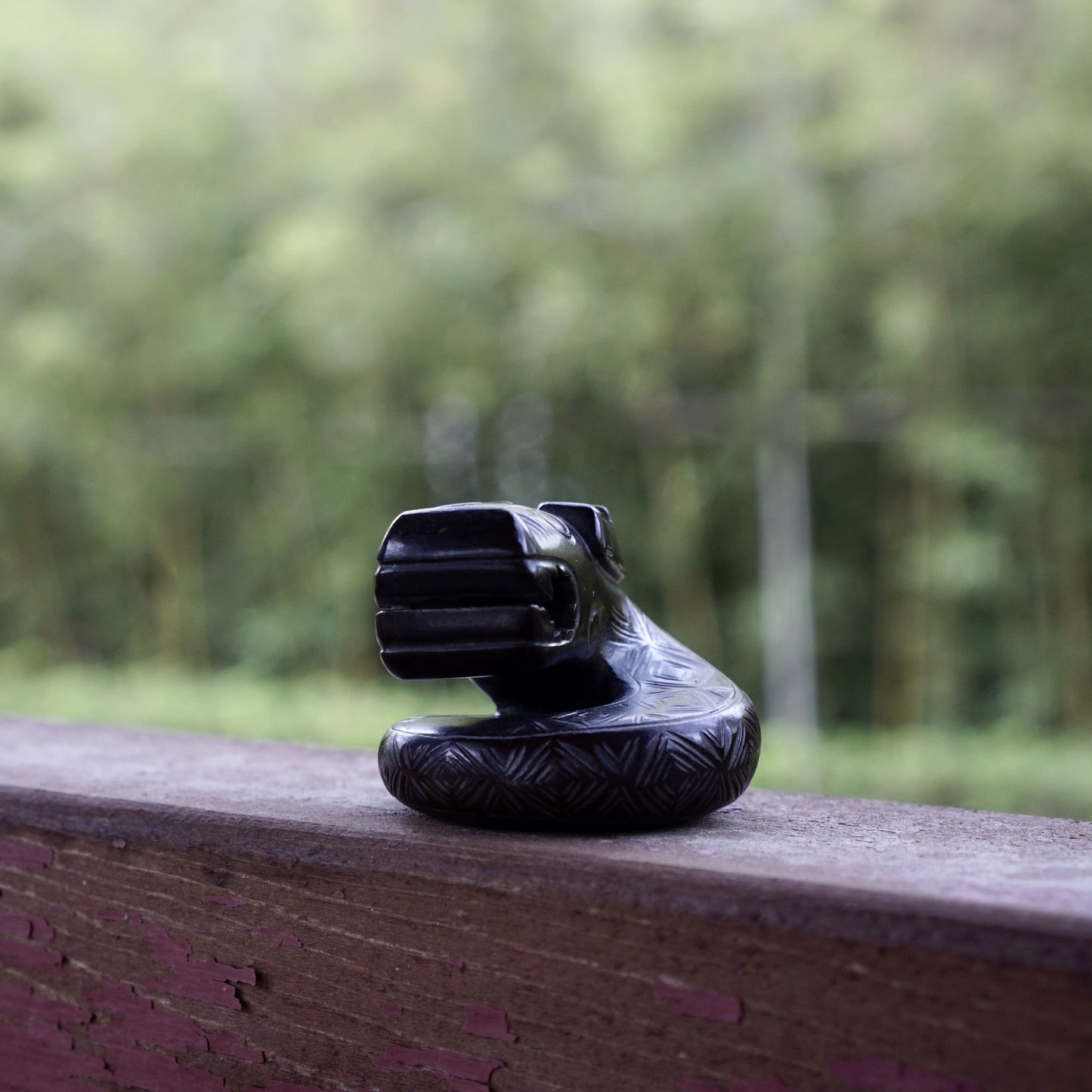 A fine round sculpture of a small dragon with black lacquer