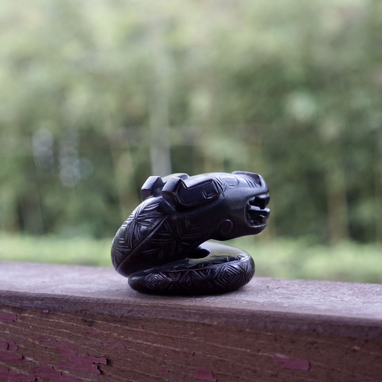 A fine round sculpture of a small dragon with black lacquer