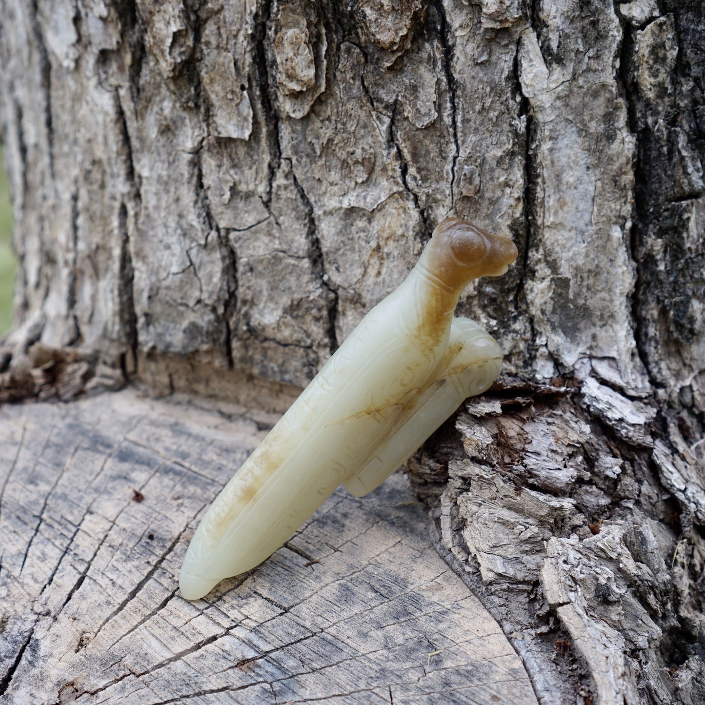 A white jade mantis with an inscription on the back