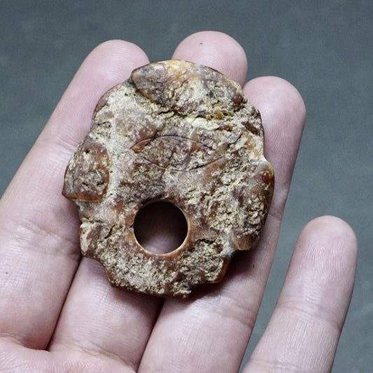 Carved human head-shaped pendant