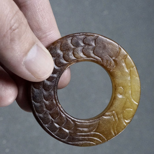 Double-sided carved jade ring with amber patina and dragon pattern