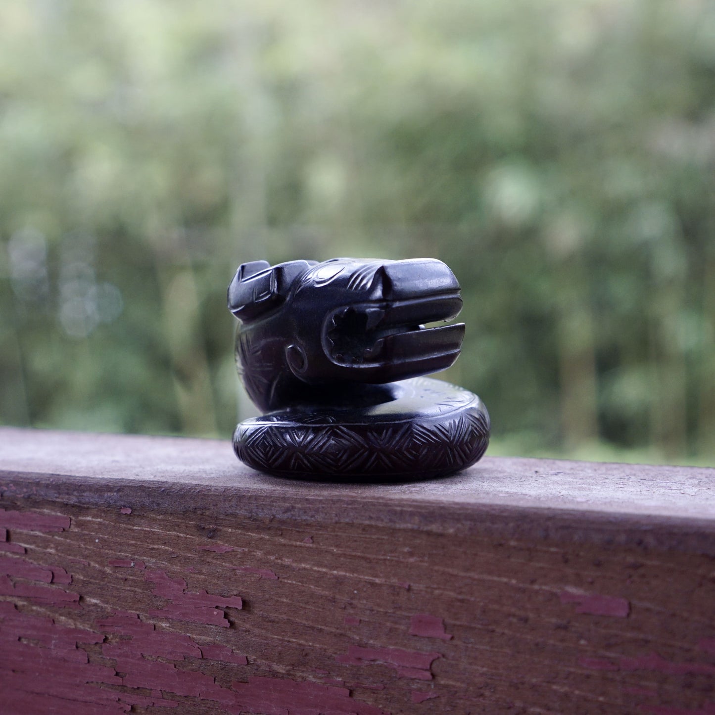 A fine round sculpture of a small dragon with black lacquer