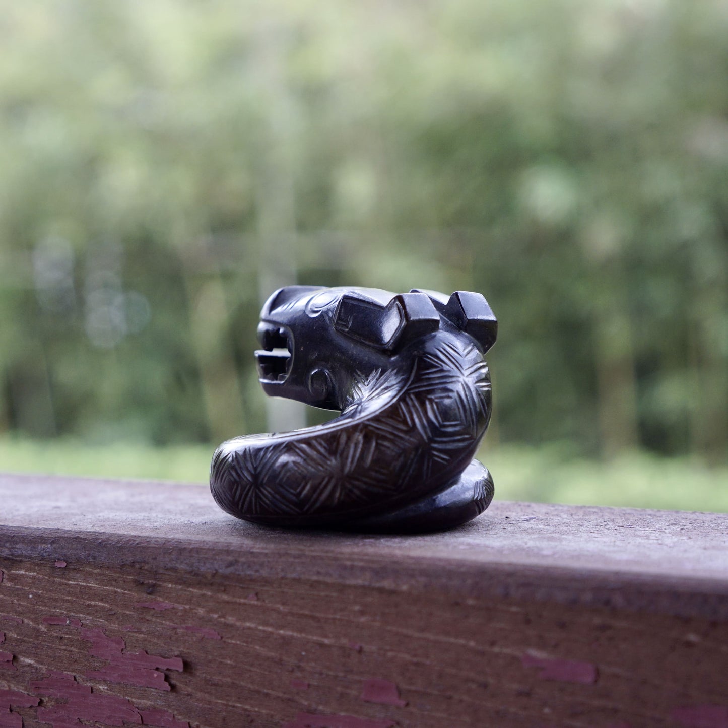 A fine round sculpture of a small dragon with black lacquer