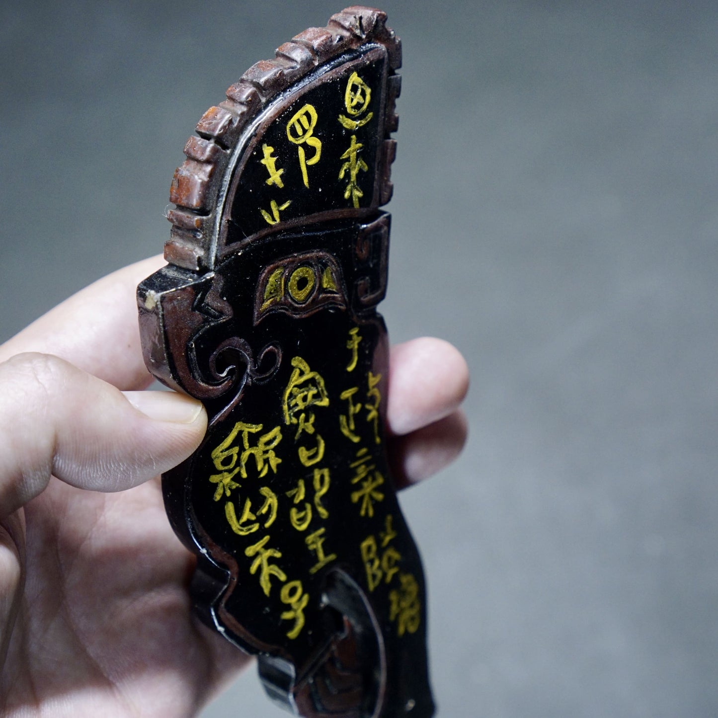 A double-sided lacquer-painted jade parrot pendant with inscriptions