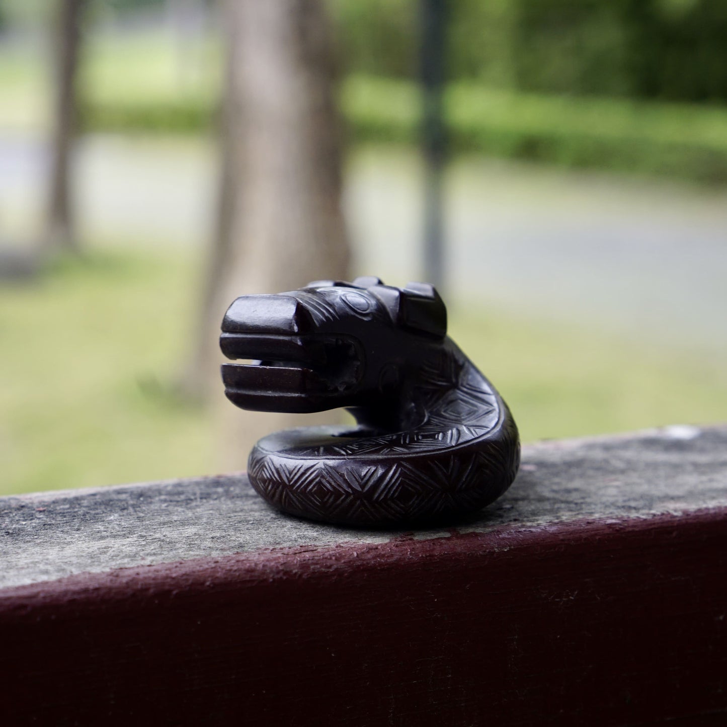 A fine round sculpture of a small dragon with black lacquer