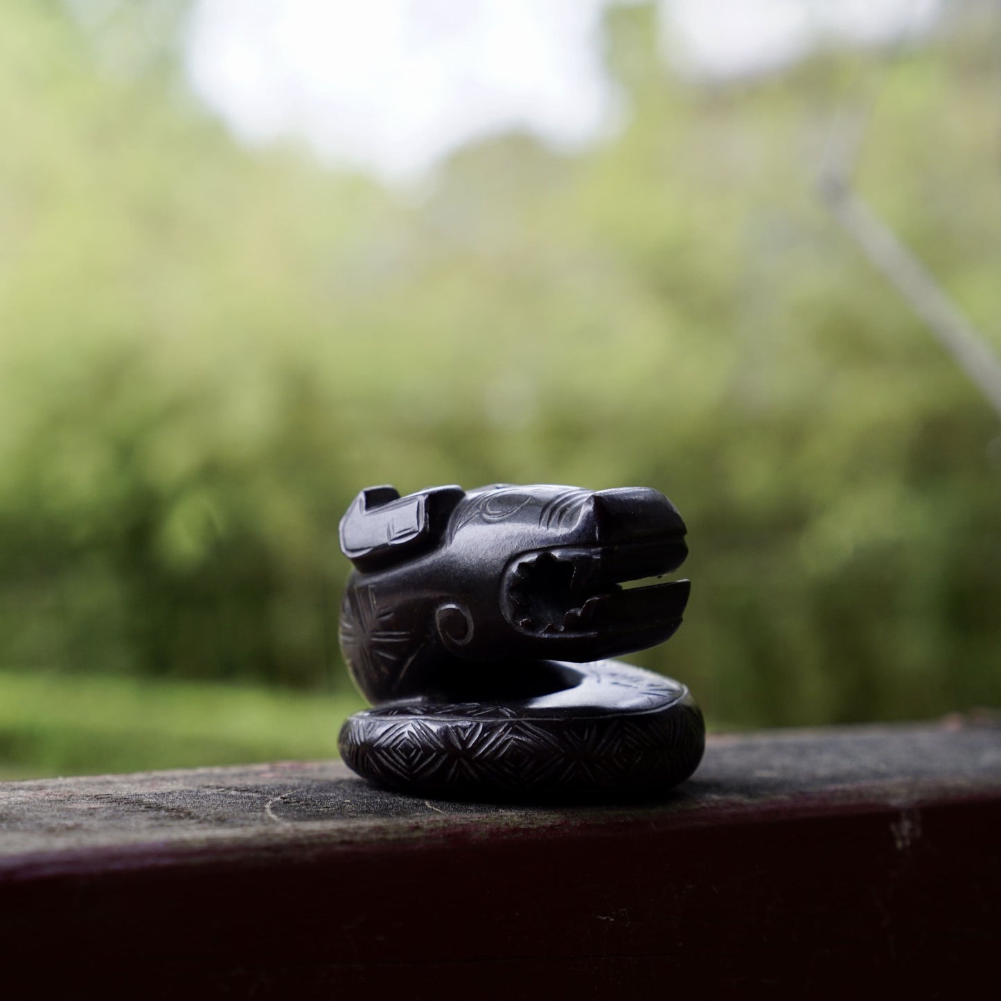 A fine round sculpture of a small dragon with black lacquer