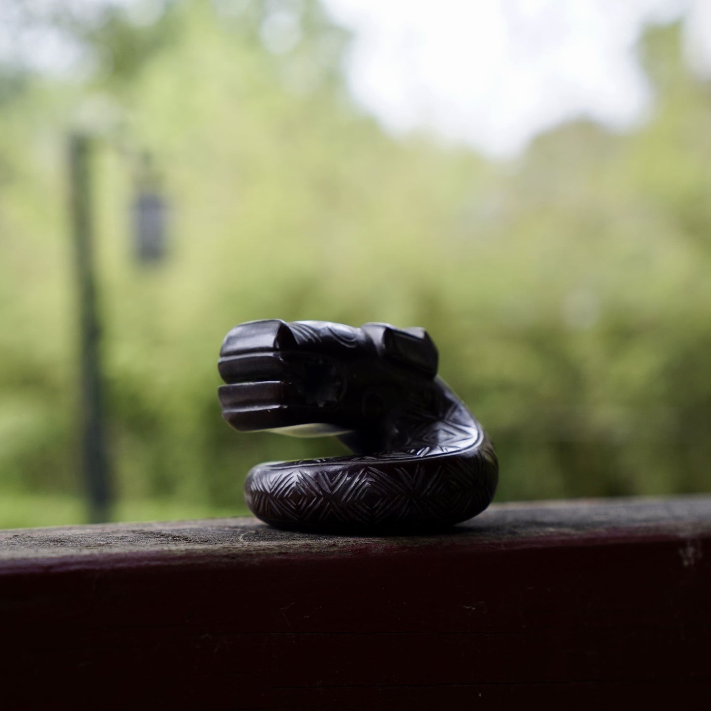 A fine round sculpture of a small dragon with black lacquer